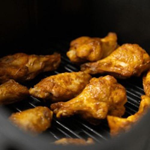 Close-up of chicken wings cooked in an air fryer in the kitchen_