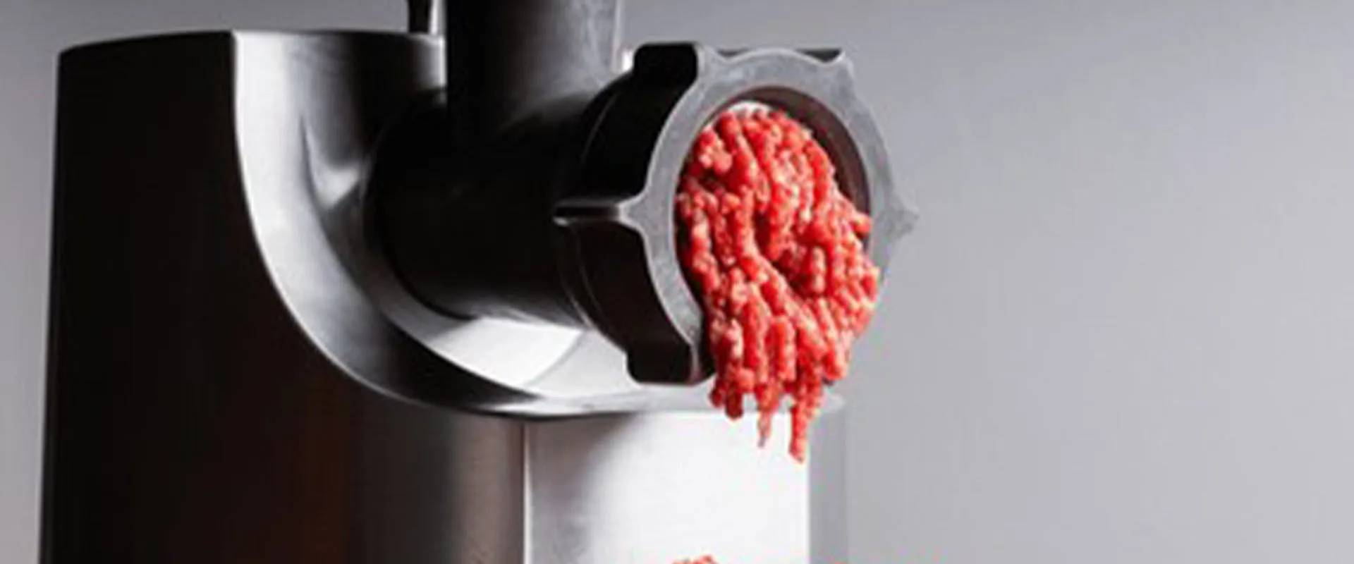 the fresh raw beef meat in the grinder The meat industry the proc